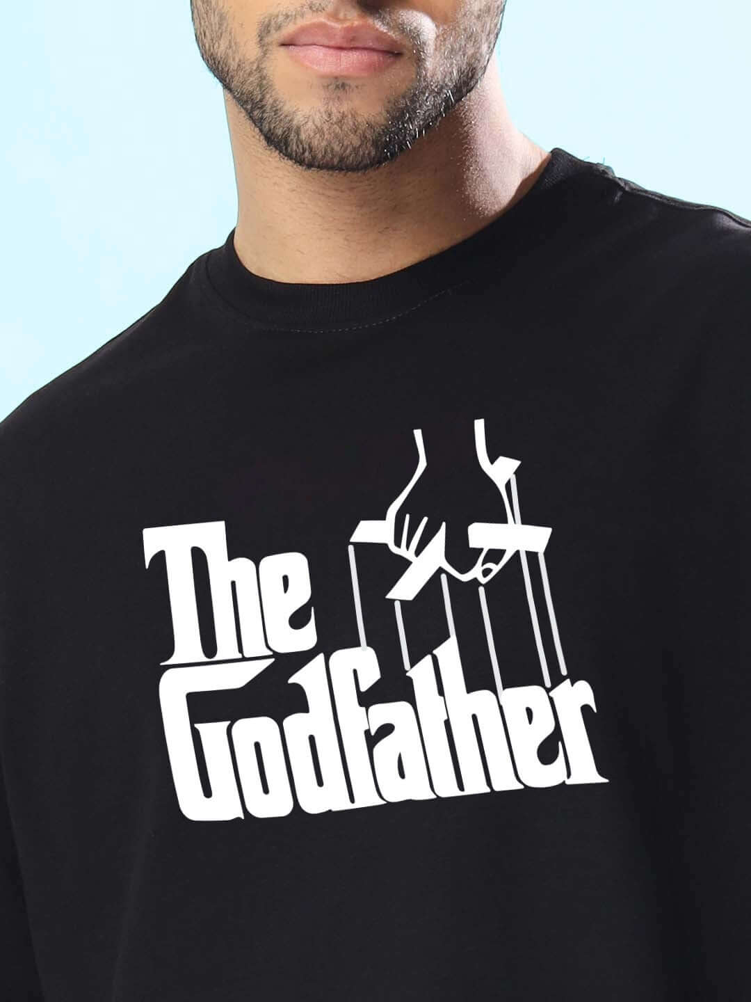 Man wearing a black oversized T-shirt with 'The Godfather' design, available for custom fit options and prepaid handmade orders from DUDS.