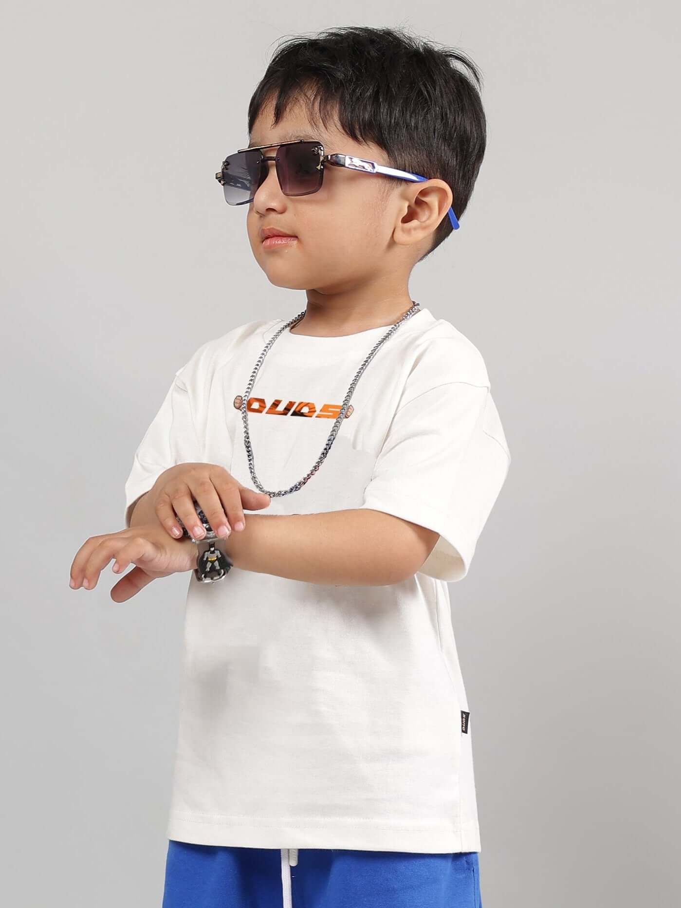Young boy wearing an off-white GOHAN T-shirt by DUDS, with sunglasses and a necklace.