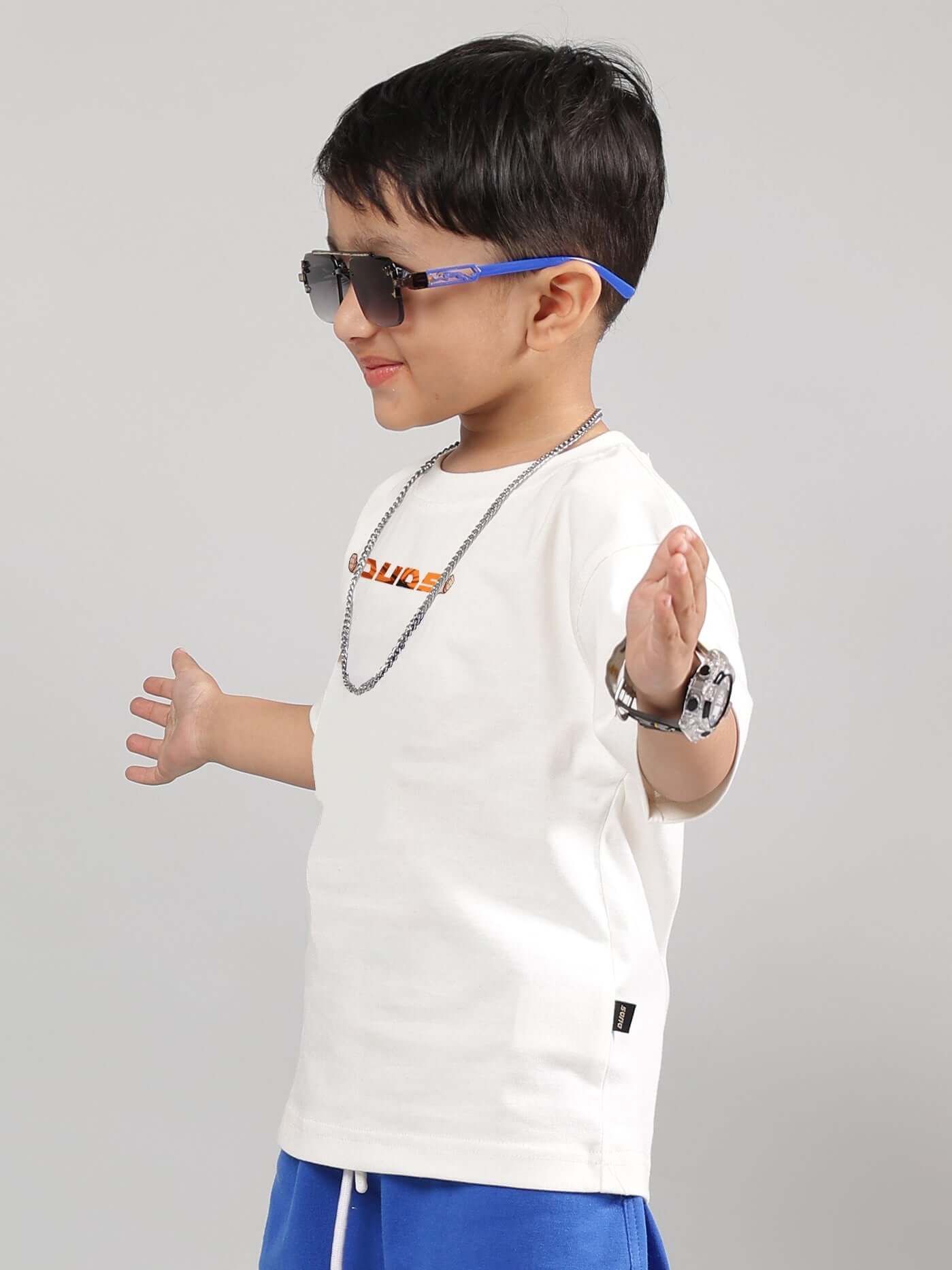 Boy wearing off-white Gohan t-shirt with sunglasses, showcasing stylish kids' fashion from DUDS.