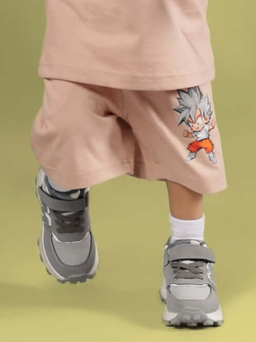 GOHAN SHORTS FOR BOYS & GIRLS BEIGE with cartoon character design, worn by a kid with sneakers.