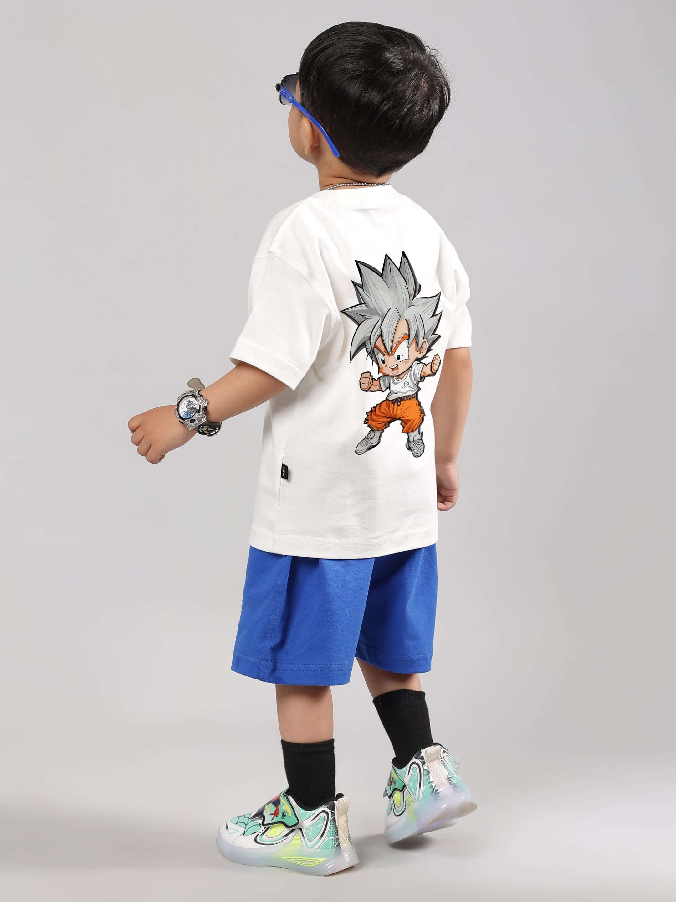 Boy wearing GOHAN SUMMER CO-ORD for boys & girls with off white t-shirt featuring anime design and blue shorts. Made-to-order by DUDS.