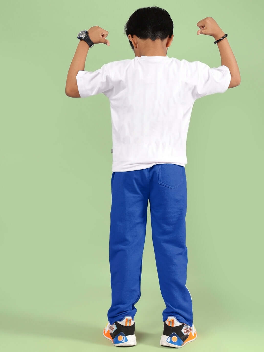 GOKU WARRIOR CO-ORD FOR BOYS & GIRLS WHITE BLUE outfit on child flexing muscles, showcasing back view.