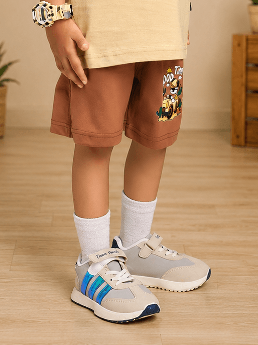GOOD TIME PRINT SHORTS FOR BOYS GIRLS BROWN worn by a child, paired with stylish sneakers and cozy socks.