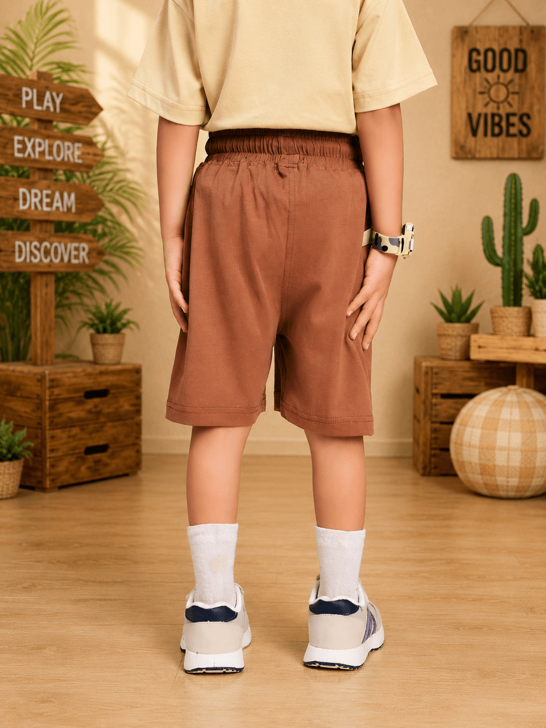 GOOD TIME PRINT SHORTS FOR BOYS GIRLS BROWN seen from the back on a child in a casual indoor setting.