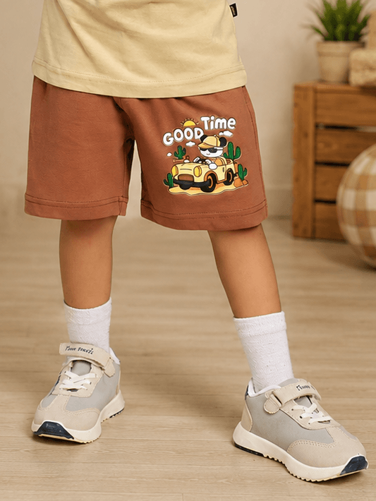 GOOD TIME PRINT SHORTS FOR BOYS GIRLS BROWN worn by a child, featuring a playful graphic design.