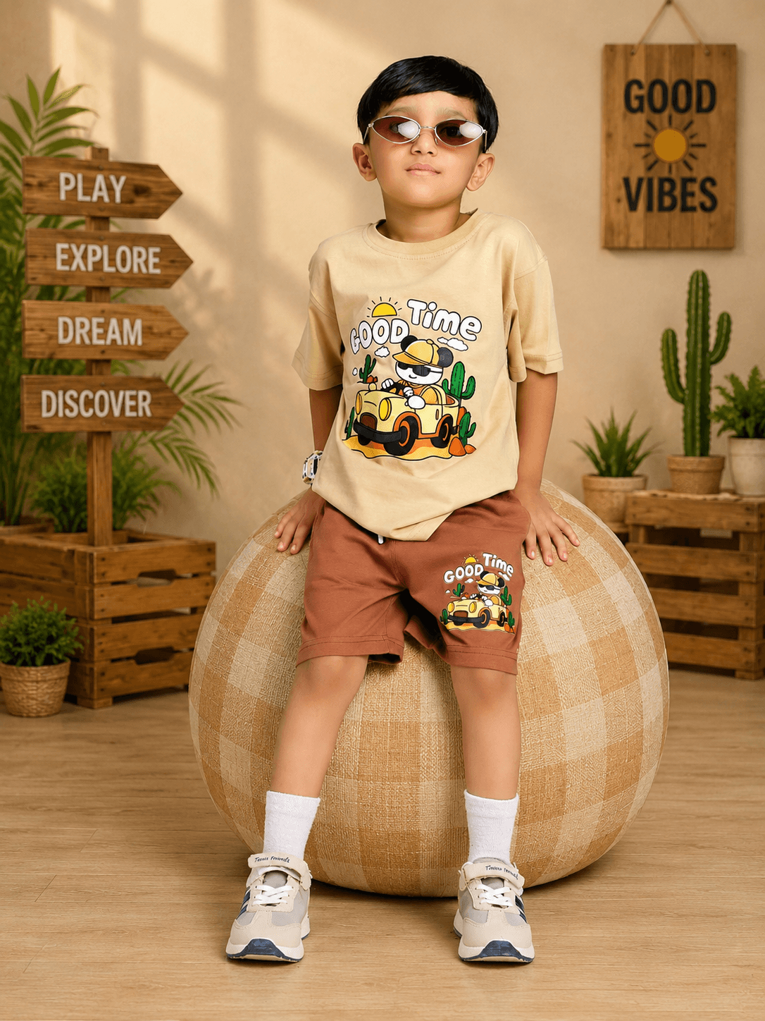 GOOD TIME PRINT T-SHIRT FOR BOYS GIRLS BEIGE worn by a boy sitting on a ball, stylish and playful in a bright setting.