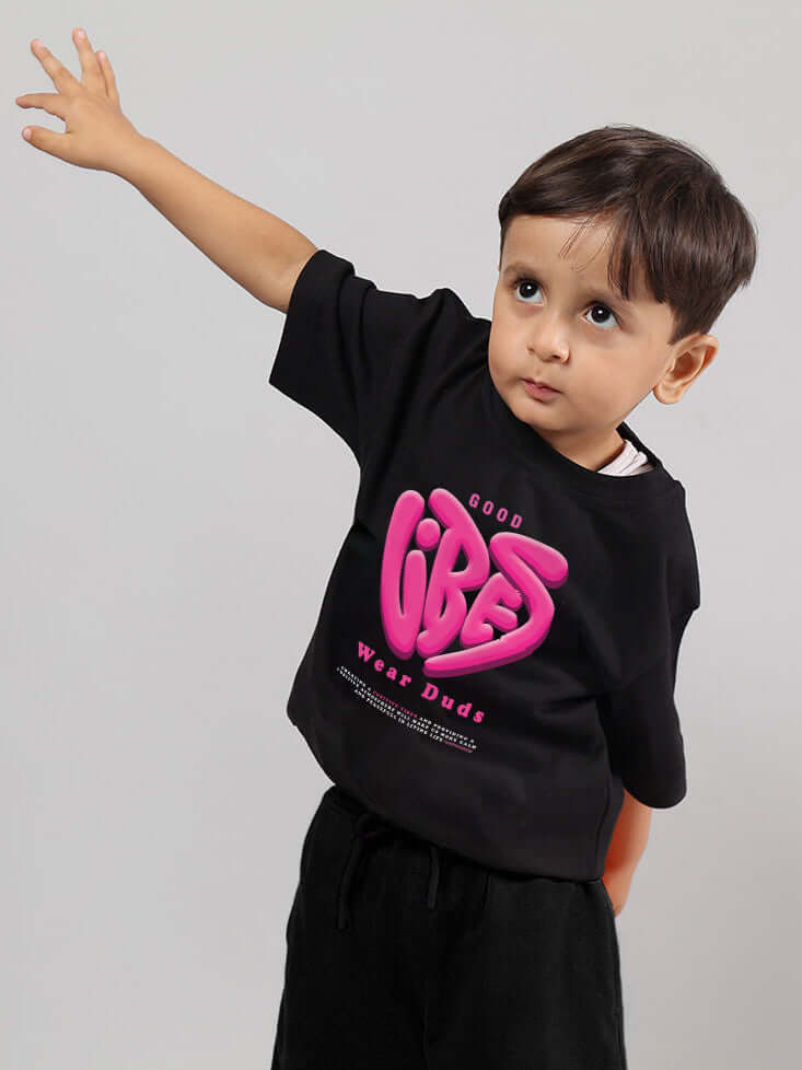 Young child wearing a black "Good Vibes" T-shirt from DUDS, perfect for boys and girls, showcasing casual style and comfort.