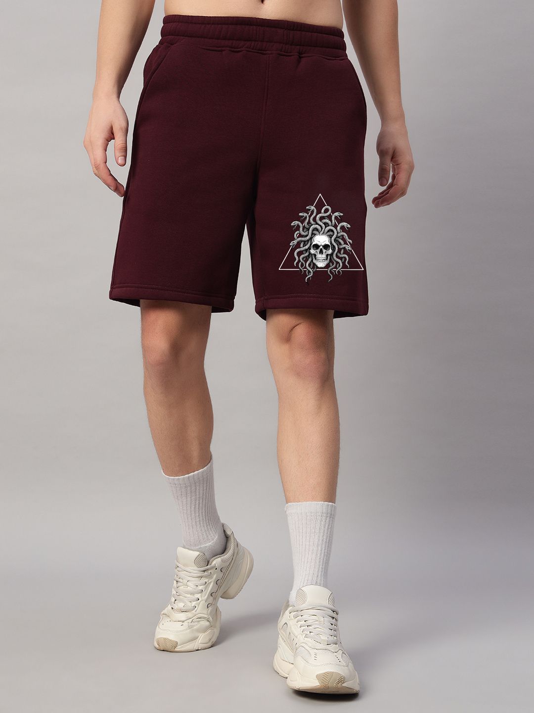 Person wearing GORGON SKULL PRINTED FLEECE CO-ORD SET WINE with striking skull graphic in streetwear style.