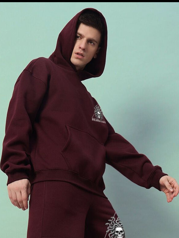 Model wearing GORGON SKULL PRINTED FLEECE HOODIE WINE with mythic skull design, showcasing bold style and comfort.