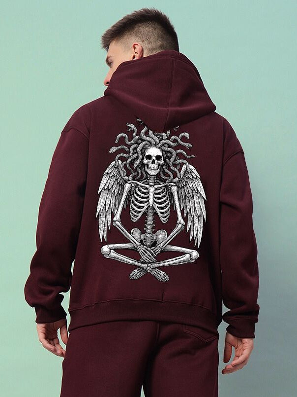 GORGON SKULL PRINTED FLEECE HOODIE WINE with a striking gorgon skull graphic on the back, worn by a model.