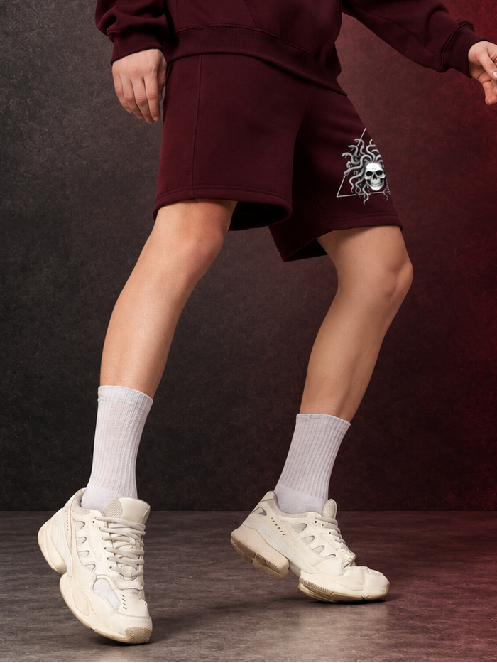 GORGON SKULL PRINTED FLEECE SHORTS WINE styled with white sneakers and socks for streetwear-inspired casual comfort