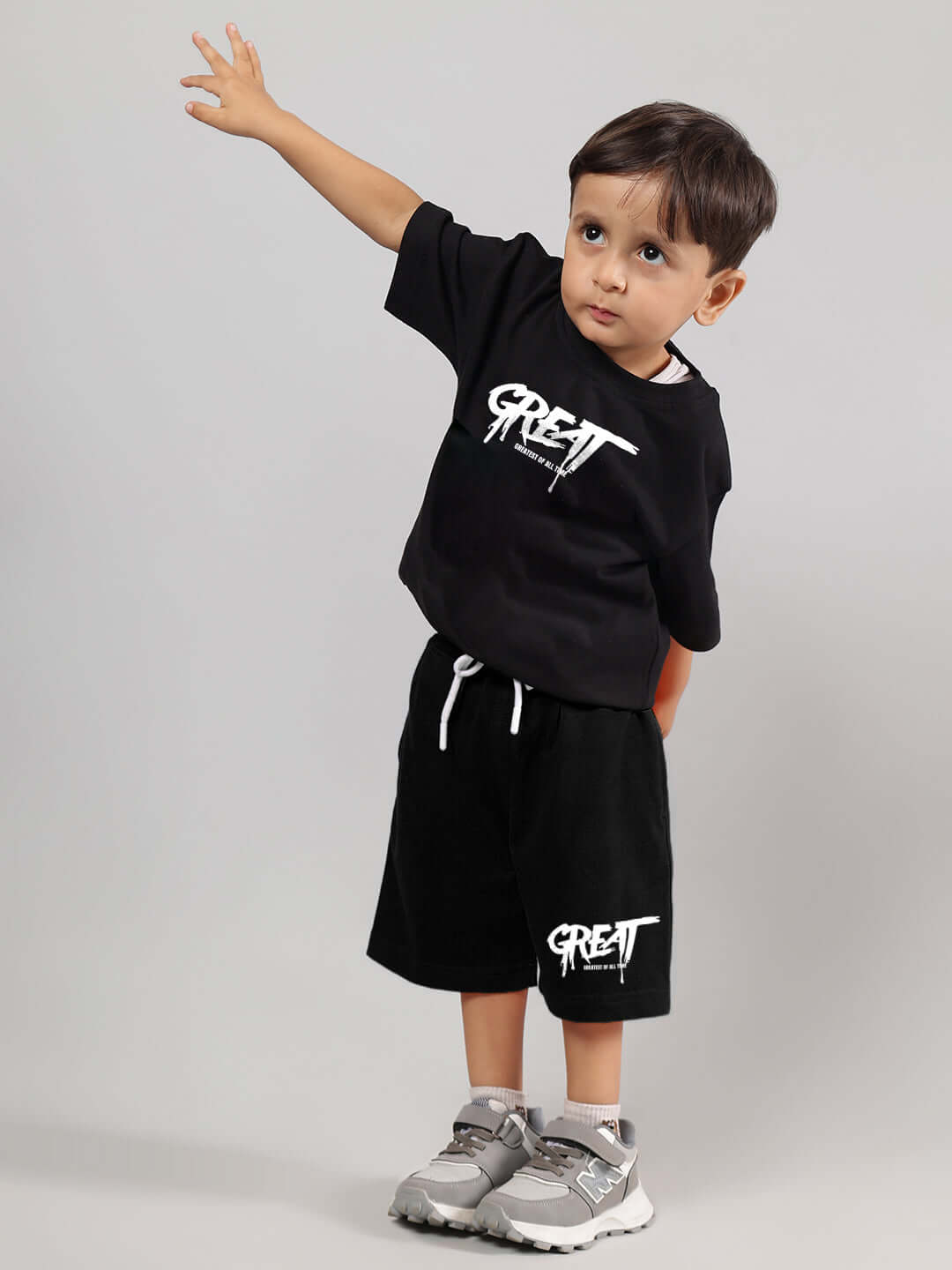 Child wearing GREAT PRINTED SUMMER CO-ORD FOR BOYS GIRLS BLACK, featuring a stylish black t-shirt and shorts set with comfortable fit.