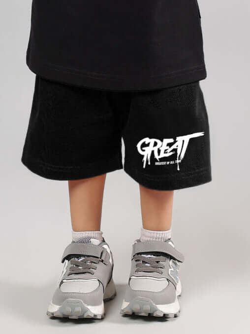 Child wearing GREAT PRINTED SUMMER SHORTS FOR BOYS GIRLS BLACK with sneakers.