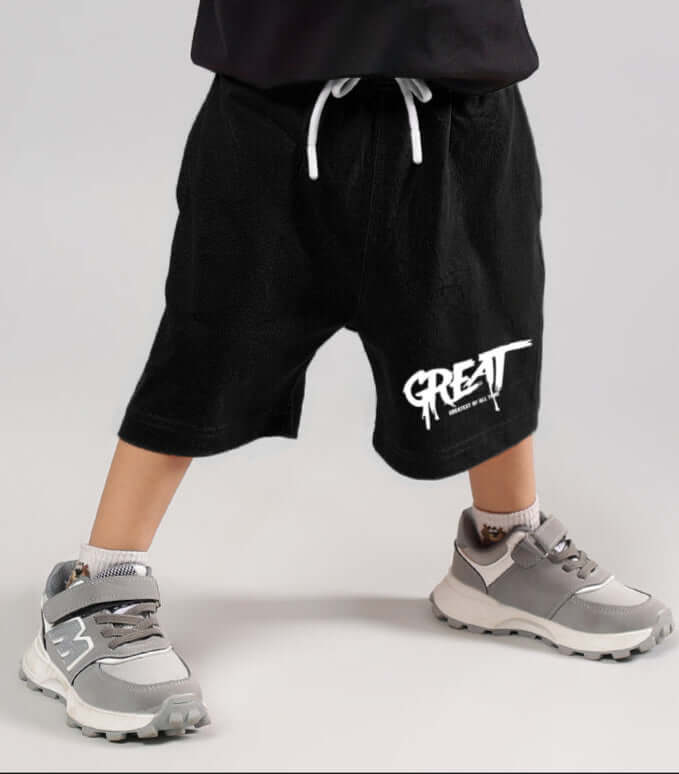 Child wearing GREAT PRINTED SUMMER SHORTS FOR BOYS GIRLS BLACK with sneakers, perfect for warm-weather adventures.