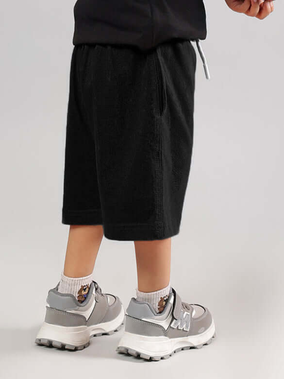 Child wearing GREAT PRINTED SUMMER SHORTS FOR BOYS GIRLS BLACK showcasing stylish and comfortable fit for summer activities.