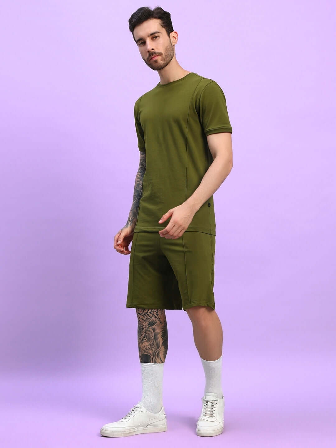 Model wearing olive green Greeble co-ord set, featuring premium cotton French terry fabric, standing against a purple backdrop.