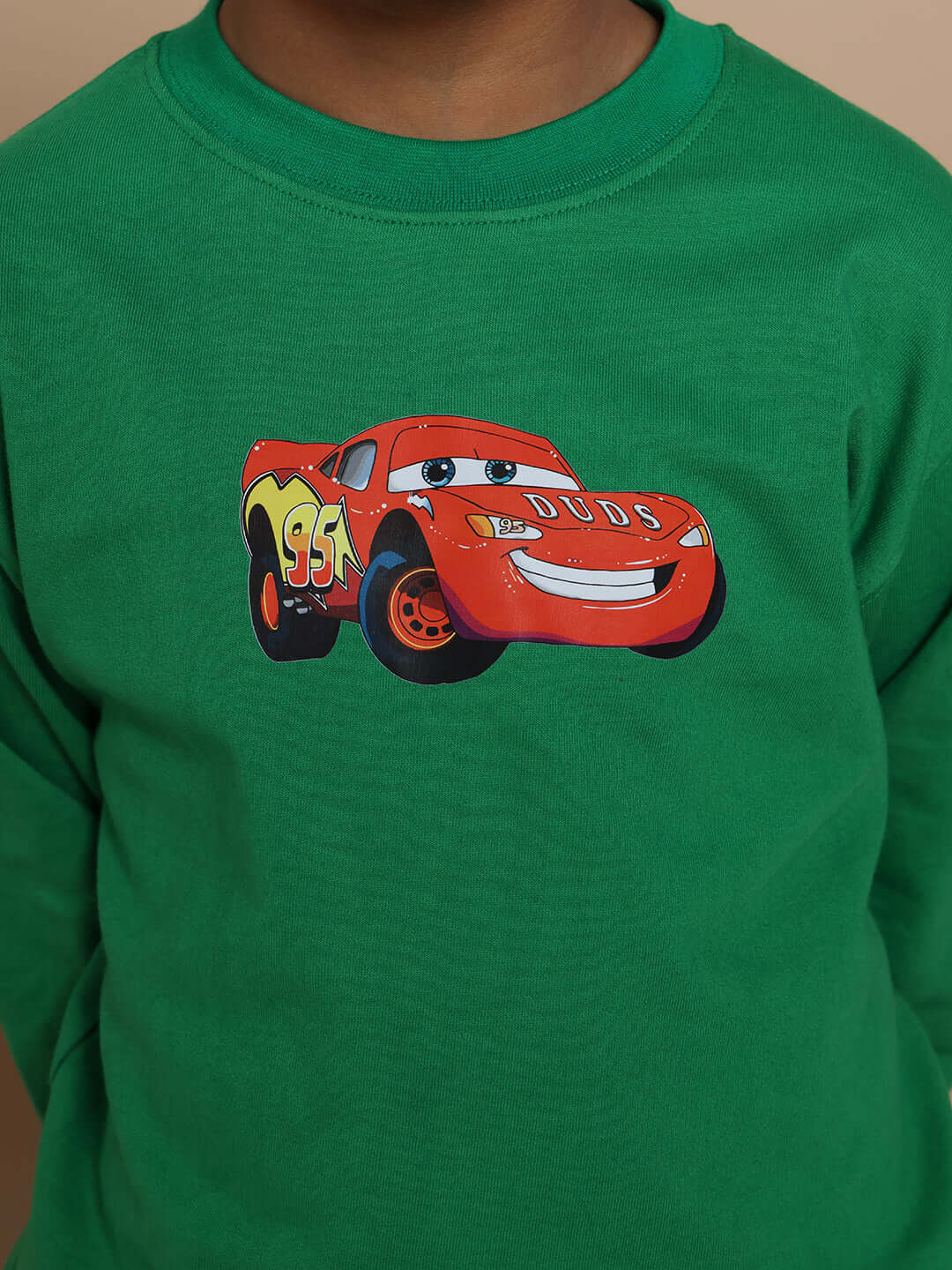 Child wearing green co-ord with red race car print, perfect for Formula 1 fans. Custom fits and tailoring by DUDS.