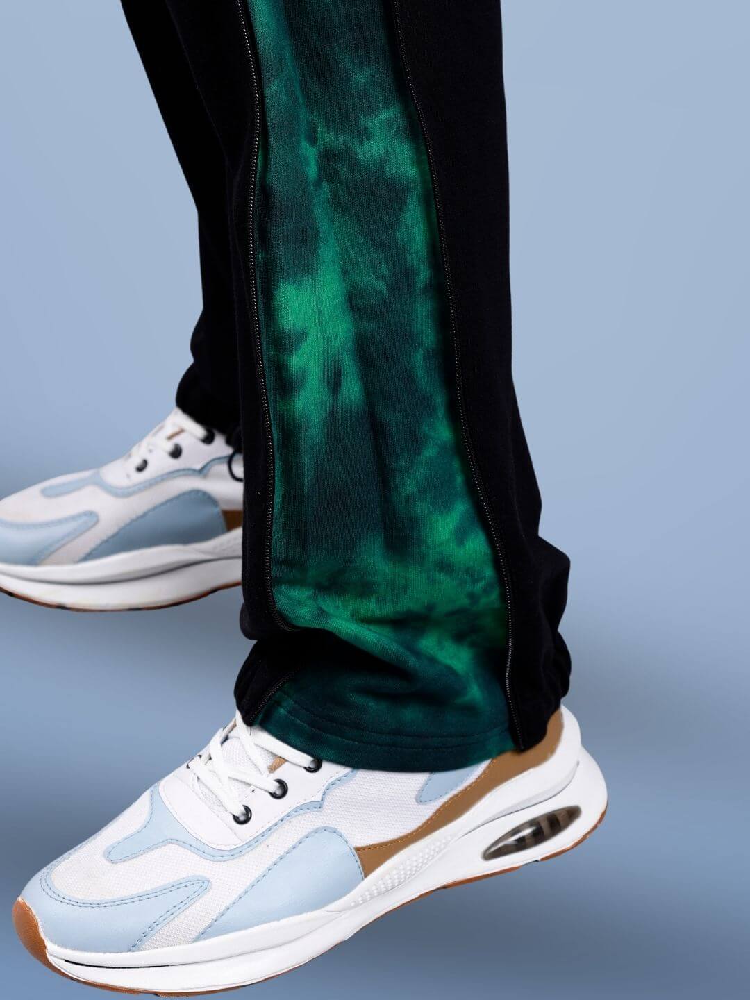Close-up of green zipper panel joggers paired with stylish white sneakers, showcasing modern athletic fashion by DUDS.