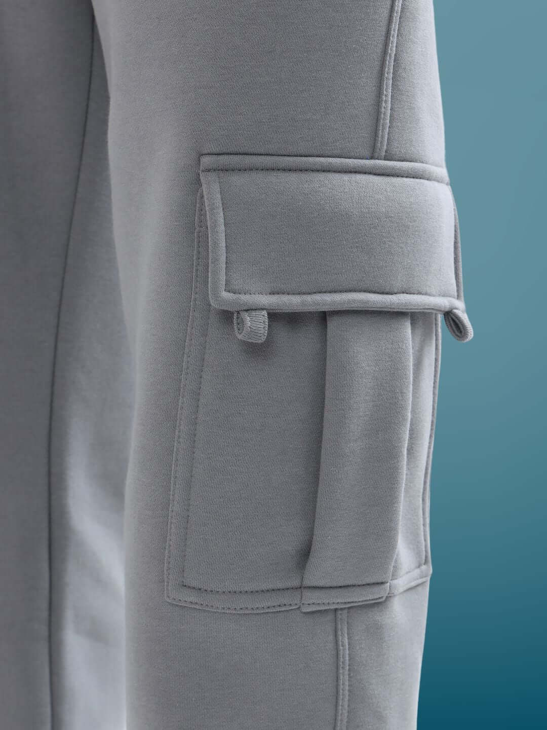 Close-up of a grey relaxed fit cargo pant pocket showcasing detailed stitching and durable fabric, perfect for a custom fit.