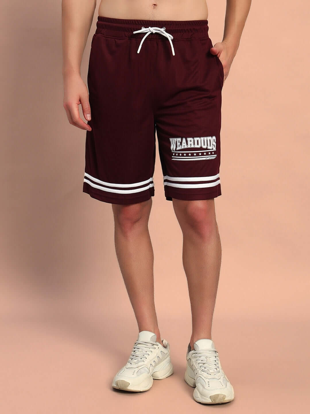 Model wearing GROOVY COLORBLOCK CO-ORD SET WINE shorts from WEAR DUDS; maroon with logo.