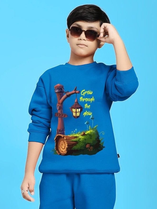 Child wearing GROW AND GLOW PRINT FLEECE SWEATSHIRT FOR BOYS GIRLS BLUE with sunglasses against a blue background.