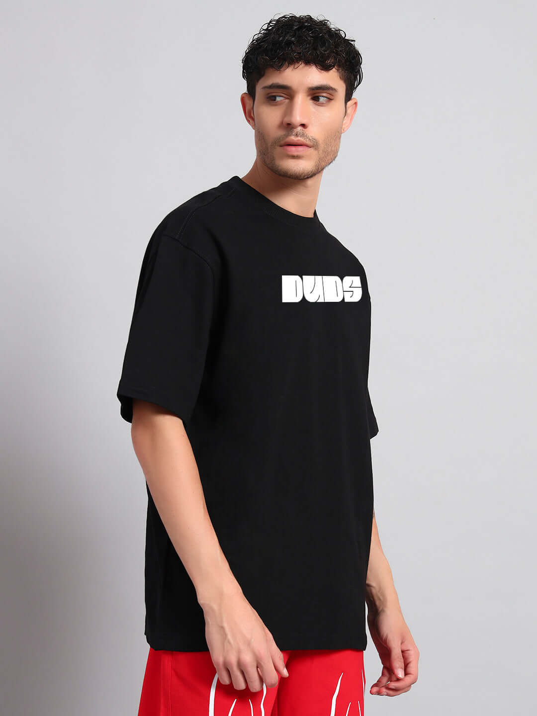 Model wearing GUNS AND ROSES OVERSIZED T-SHIRT BLACK, showcasing edgy streetwear style.