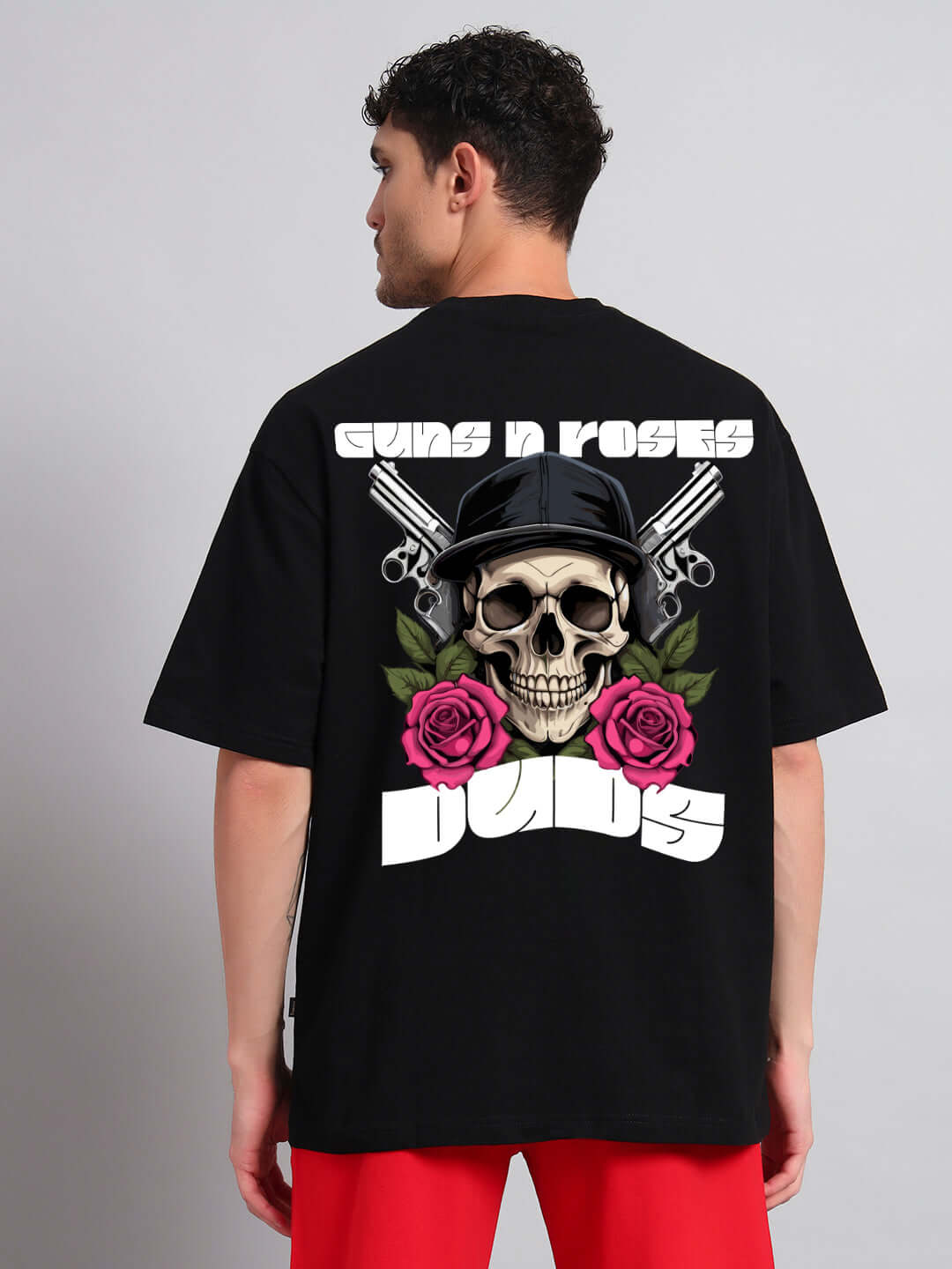 Black oversized t-shirt featuring Guns N' Roses logo with skull and roses design, worn by a man facing away.
