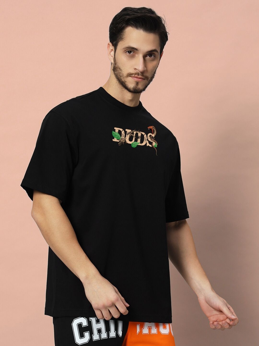Model wearing HAND SNAKE APPLE OVERSIZED T-SHIRT BLACK with unique snake design and relaxed fit, perfect for casual style.