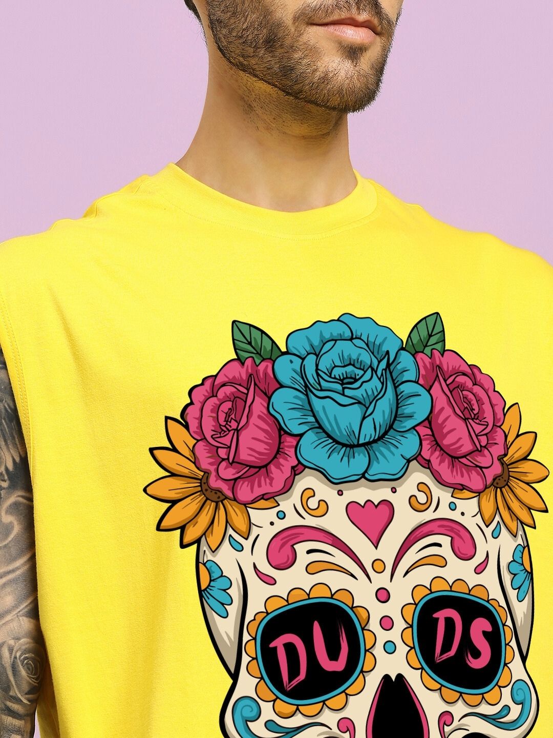 Person wearing HAPPY SKULL PRINTED GYM T-SHIRT YELLOW with colorful skull design and floral elements.