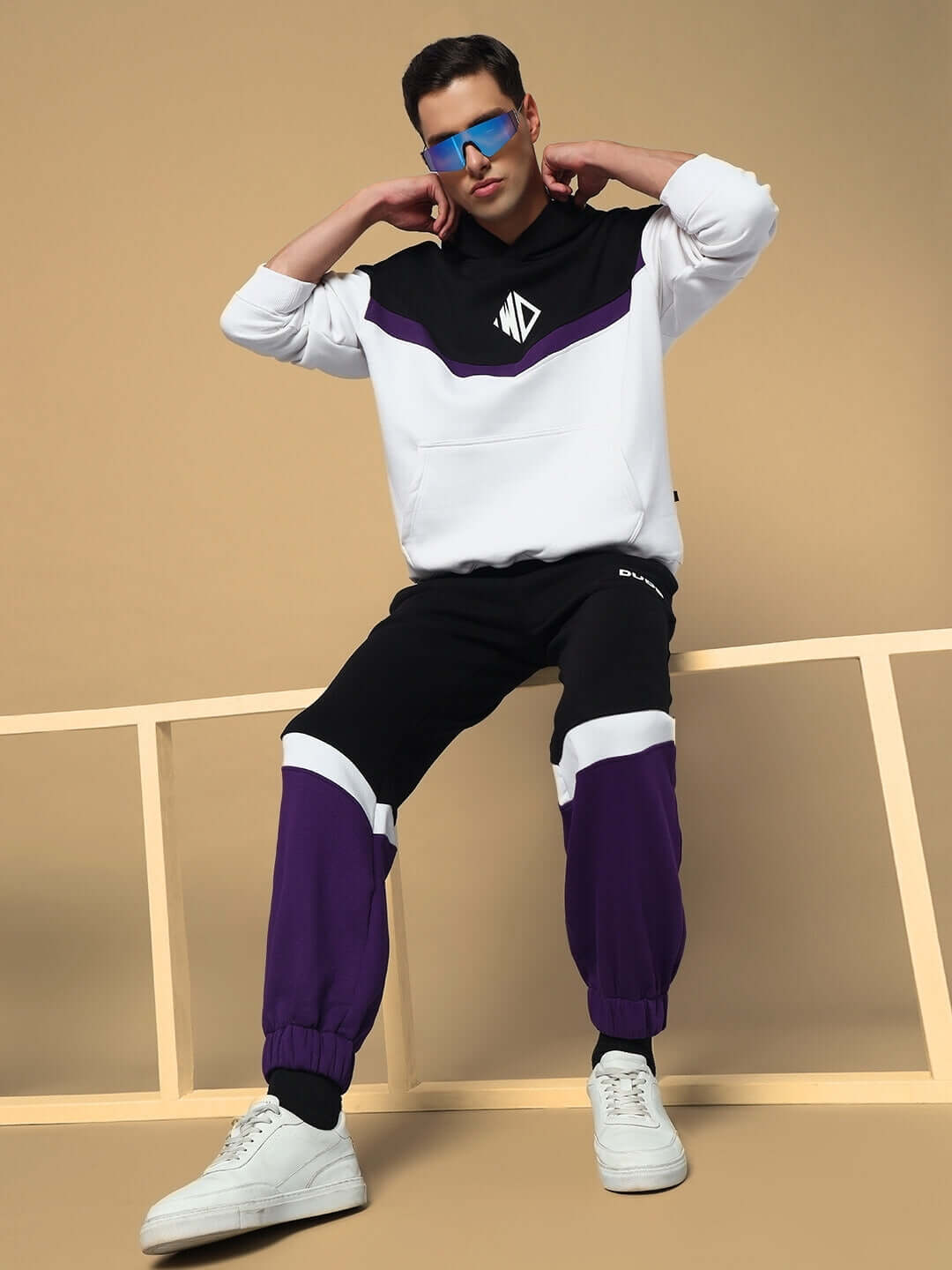 Man wearing HARLEY FLEECE COLORBLOCK HOODIE WHITE PURPLE with bold design, showcasing streetwear style in vibrant colors.