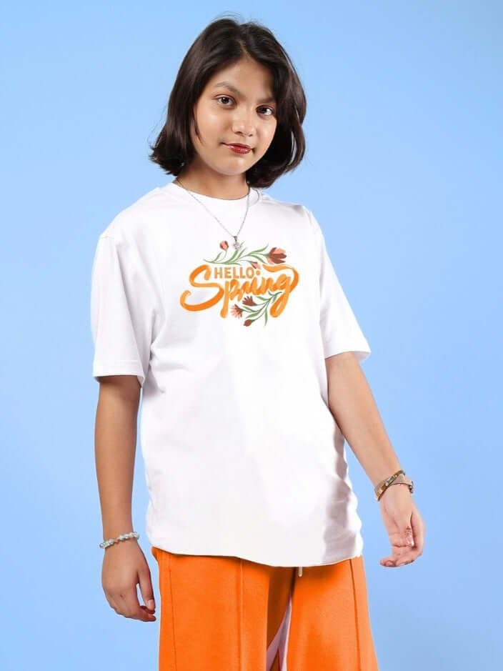 Child wearing HELLO SPRING T-SHIRT FOR BOYS & GIRLS WHITE with floral orange print, perfect for spring outfits. Tailored by DUDS.