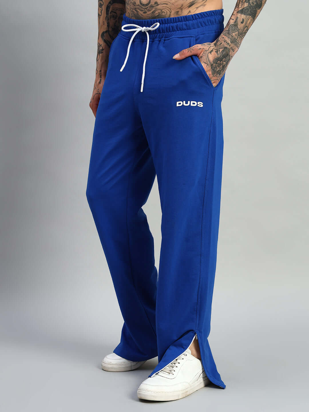 Man wearing Hershey side slit joggers in royal blue by DUDS, customizable fit, made-to-order joggers with white sneakers.