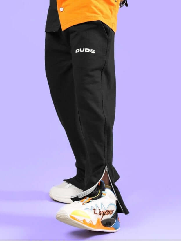 HERSHEY JOGGER FOR BOYS & GIRLS BLACK by DUDS, stylish kids' jogger pants, shown with colorful sneakers on purple background.