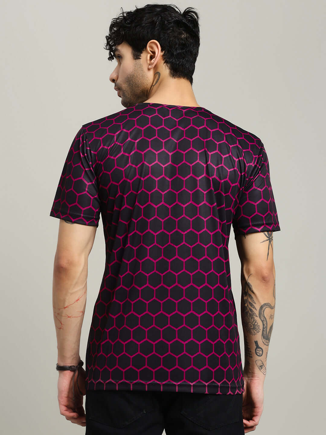 Model wearing black hexagon printed regular fit t-shirt, back view. Crafted from sports polyester for comfort and style.
