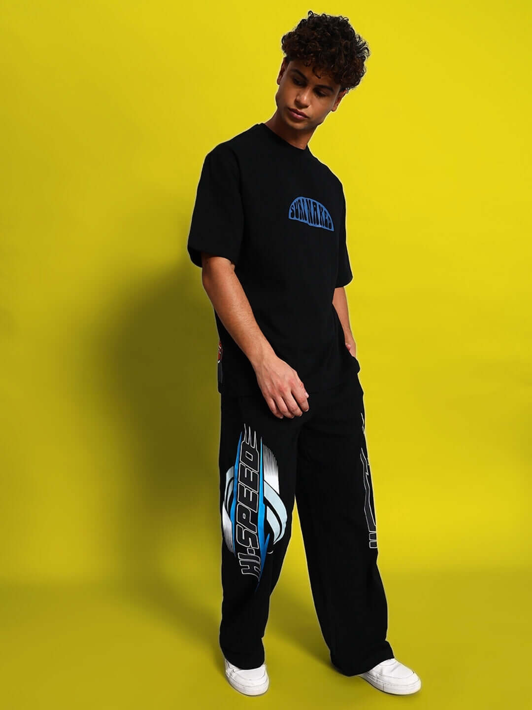 Model wearing black HI-SPEED RELAXED FIT JOGGER by DUDS on yellow background, showcasing comfortable style.