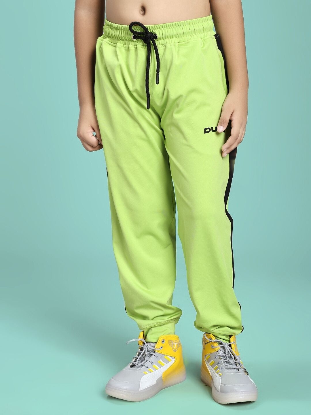 Child wearing HIGH PERFORMANCE CO-ORD SET FOR BOYS AND GIRLS NEON GREEN pants, showcasing comfort and style for active kids.