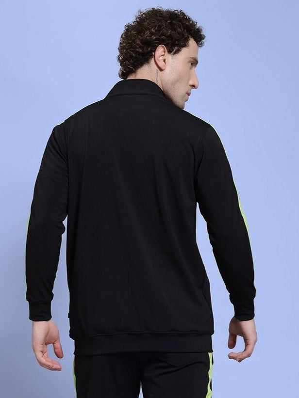 Back view of man wearing HIGH PERFORMANCE JACKET IN BLACK showcasing weather-resistant design.