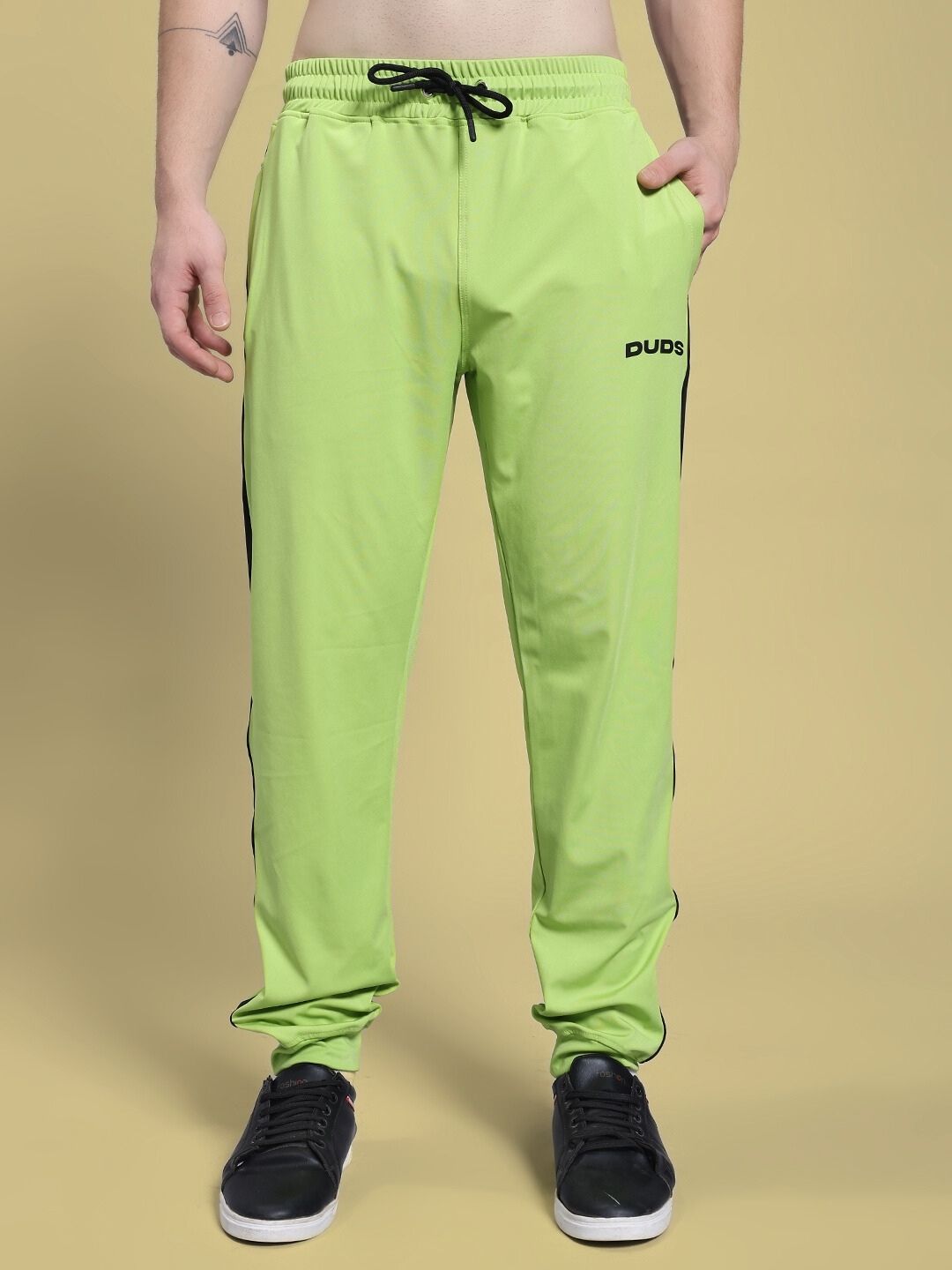 Person wearing HIGH PERFORMANCE RELAXED FIT JOGGER NEON GREEN with black drawstring, showcasing style and comfort.