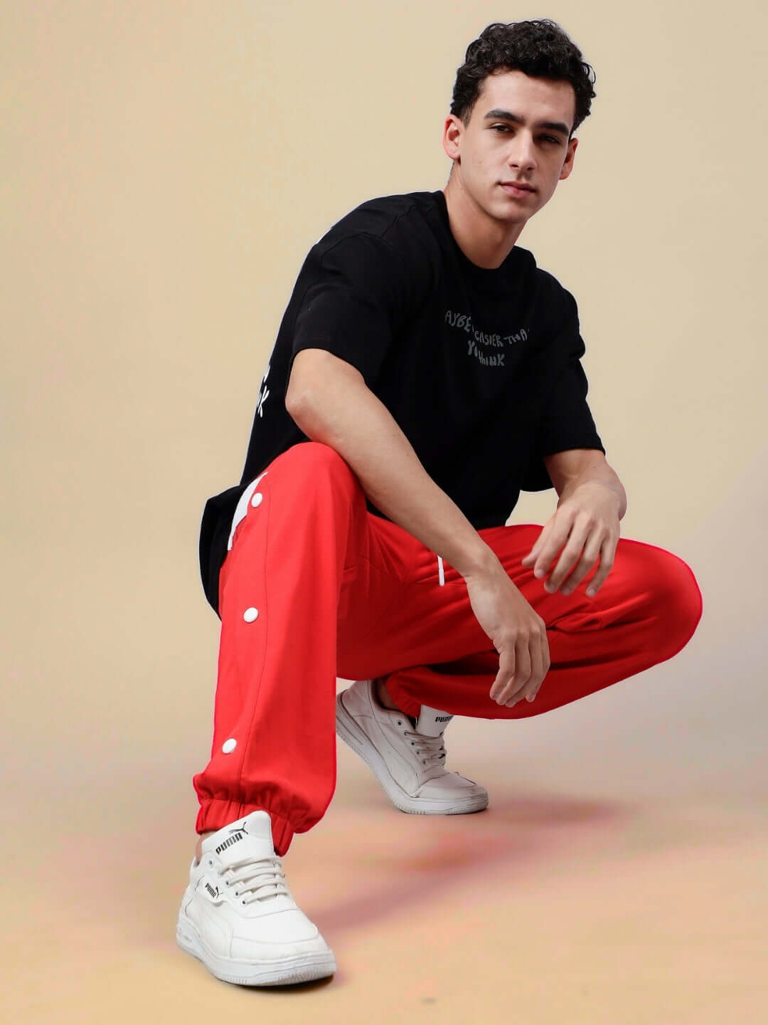 Model wearing HIGH POINT CONTRAST JOGGERS in red and white with casual black shirt and white sneakers, showcasing style and comfort.