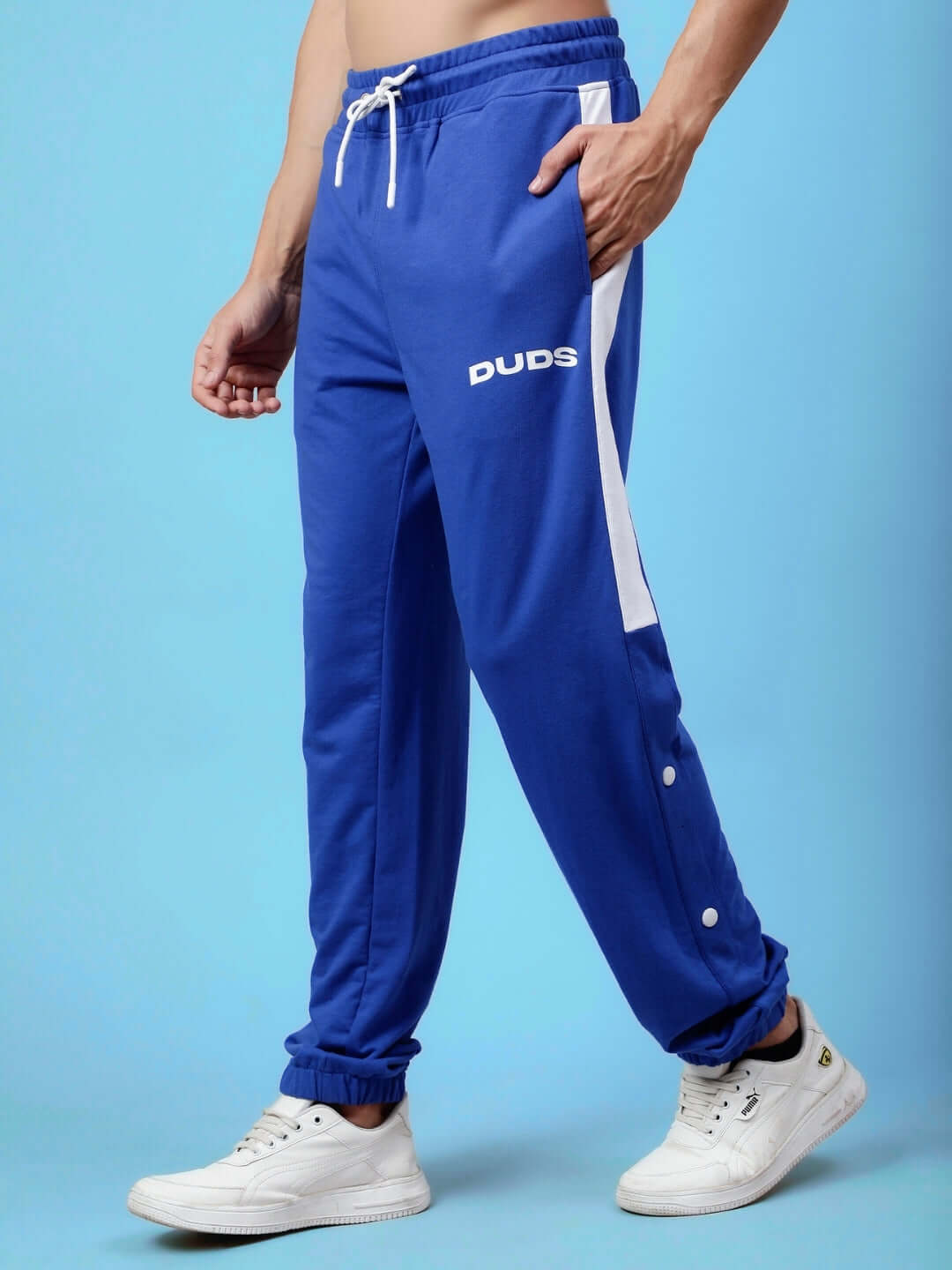 Man wearing DUDS High Point Contrast Joggers in royal blue and white, showcasing athletic fit and side stripe design.