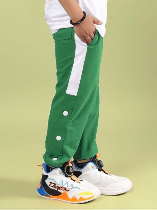 Child wearing HIGH POINT JOGGER FOR BOYS & GIRLS GREEN, standing against a light background, showcasing green joggers with white accents.