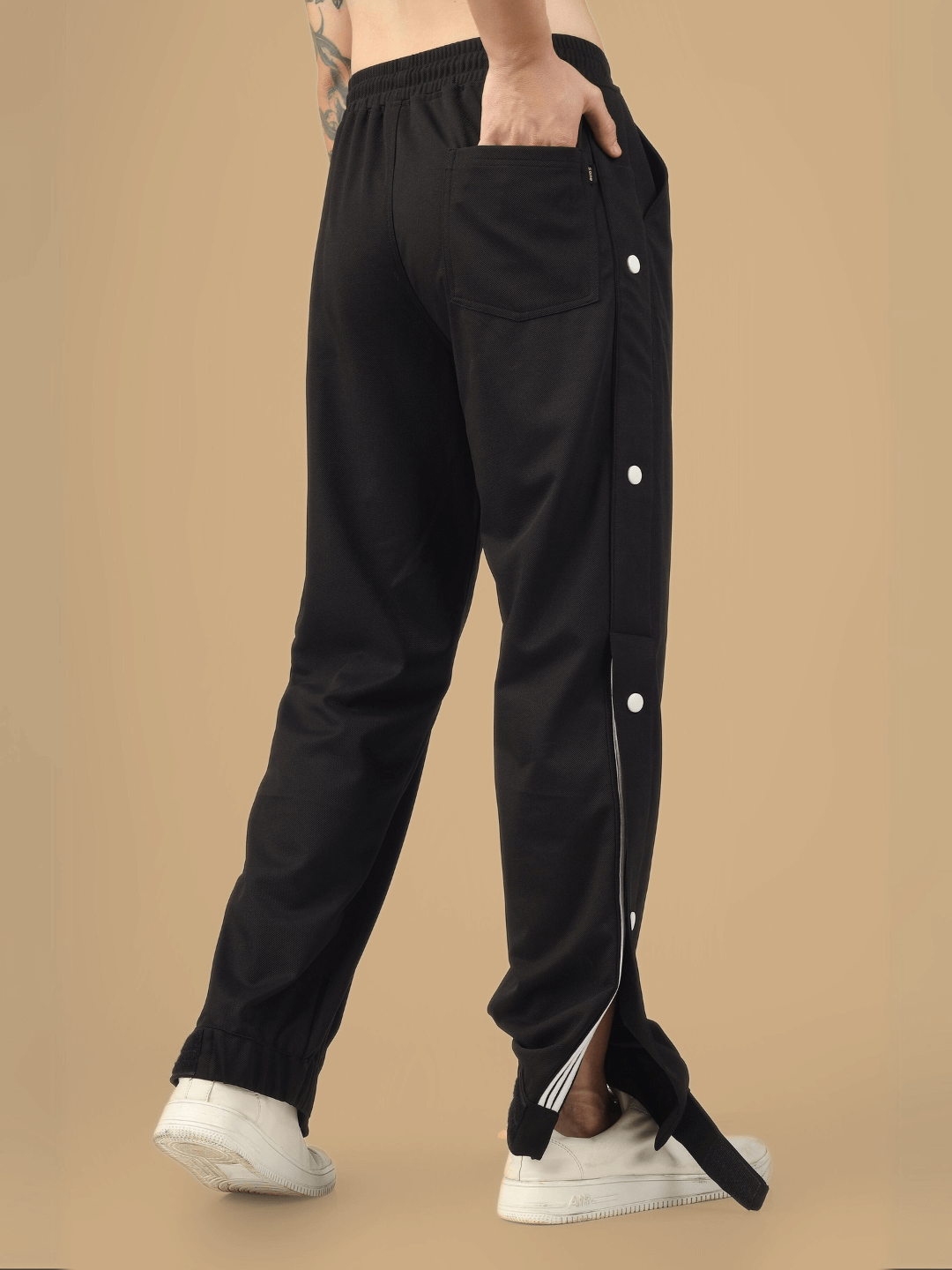 Back view of black hip hop joggers with white buttons, showcasing casual style and comfortable fit. Custom sizing available.