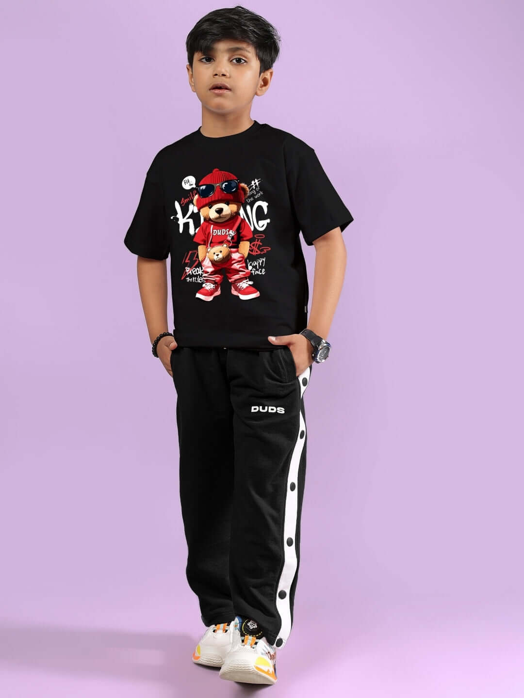 Child wearing black hip hop teddy co-ord outfit with graphic t-shirt and jogger pants, designed for boys and girls.