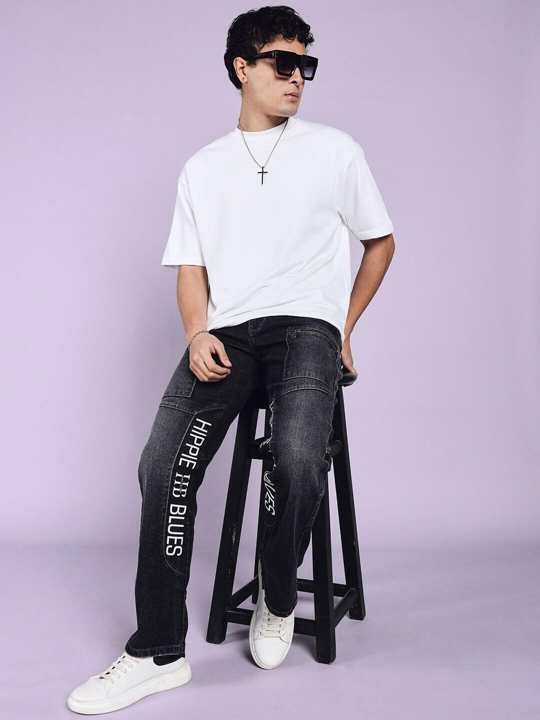Model wearing Hippie Black Regular Fit Denim Jeans with custom fit option, paired with white sneakers and a casual white t-shirt.