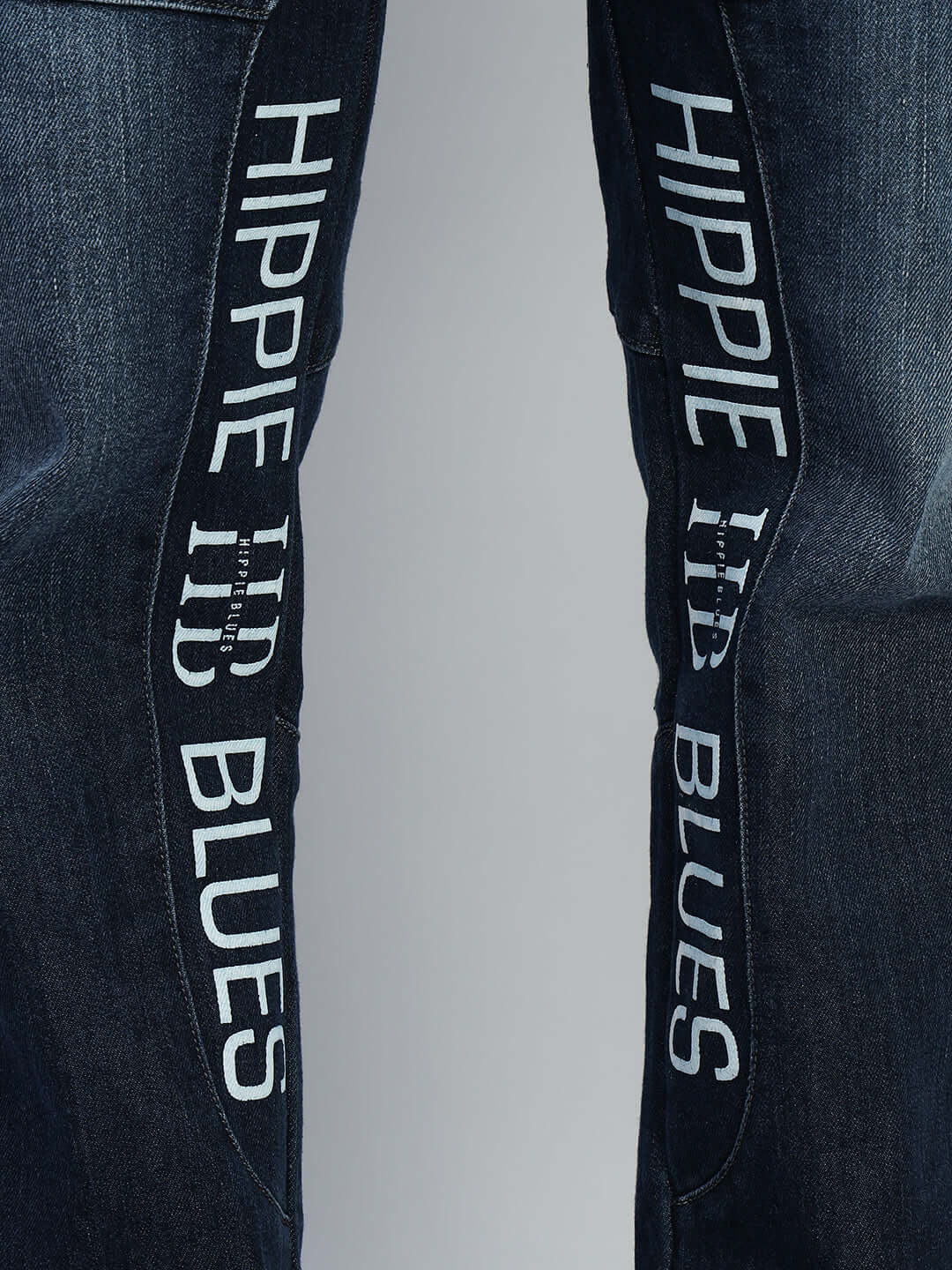 Close-up of Hippie Blue regular fit denim jeans showcasing embroidered detailing on blue fabric.