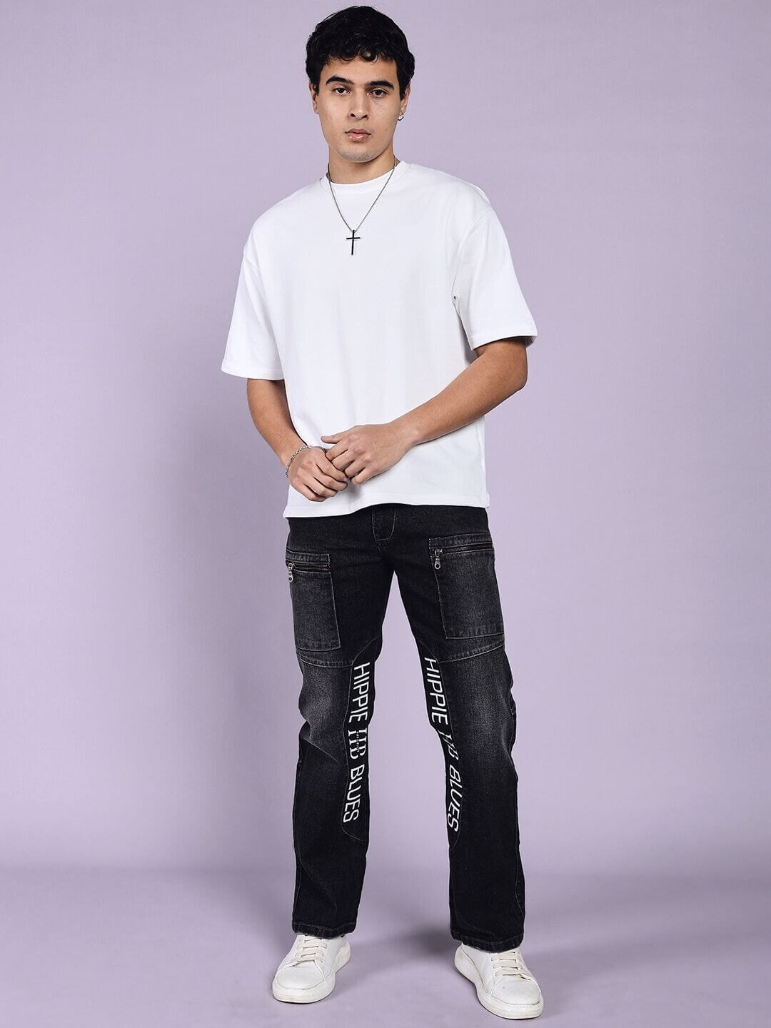 Model wearing HIPPIE BLACK regular fit denim jeans in black by DUDS, paired with a white t-shirt, showcasing casual style.