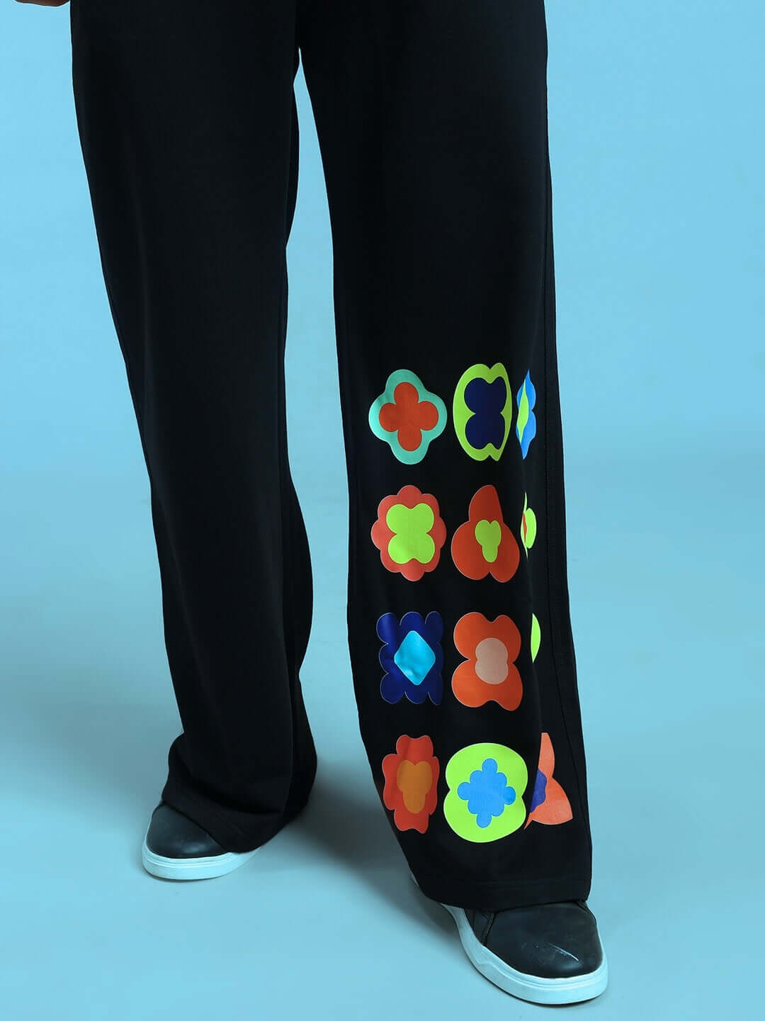 HOLLISTER COTTON JOGGERS BLACK with colorful floral patterns and white sneakers against blue background