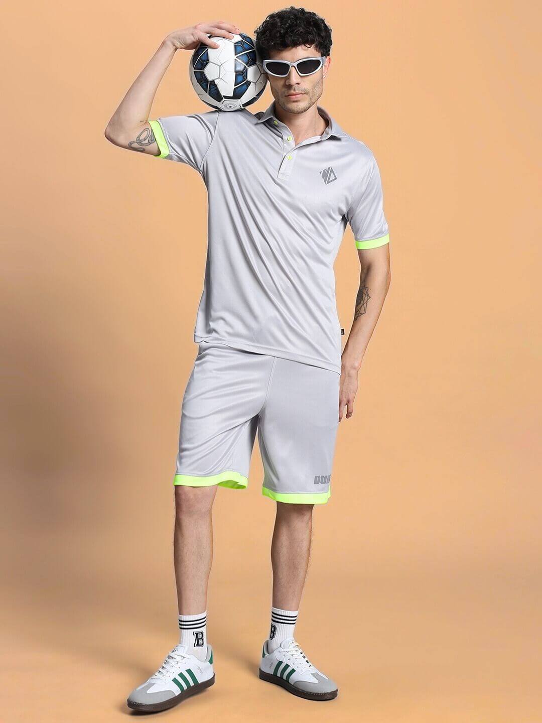 Man modeling HOOKUP REGULAR FIT SHORTS GREY with a soccer ball, showcasing comfort and style in casual sporty attire.