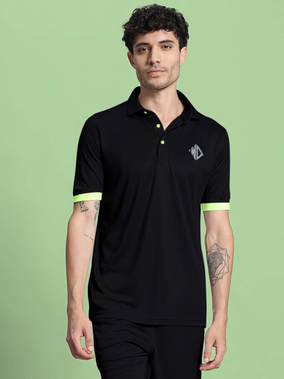 Black regular fit t-shirt in premium polyester fabric with neon accents, modeled against a green backdrop. Ideal for sports and casual wear.