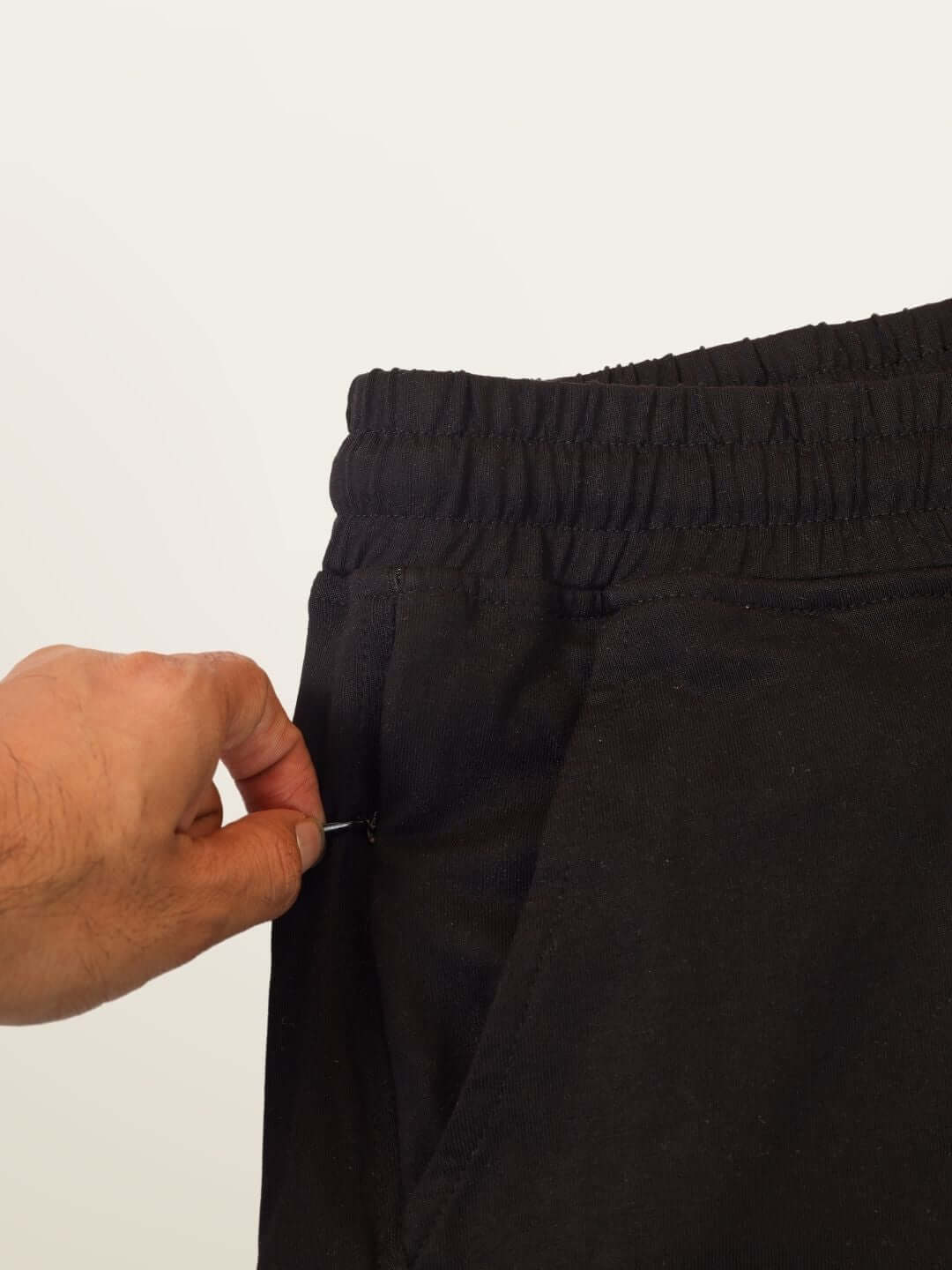 Close-up of black Hope regular fit shorts with elastic waistband, showcasing pocket detail for custom fit option.